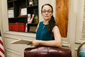 Femme d'affaires confiante dans un bureau d'entreprise tenant un dossier, démontrant son professionnalisme et son expertise.