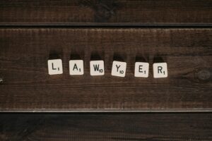 Gros plan de tuiles de Scrabble portant le mot « avocat » sur une surface en bois sombre.
